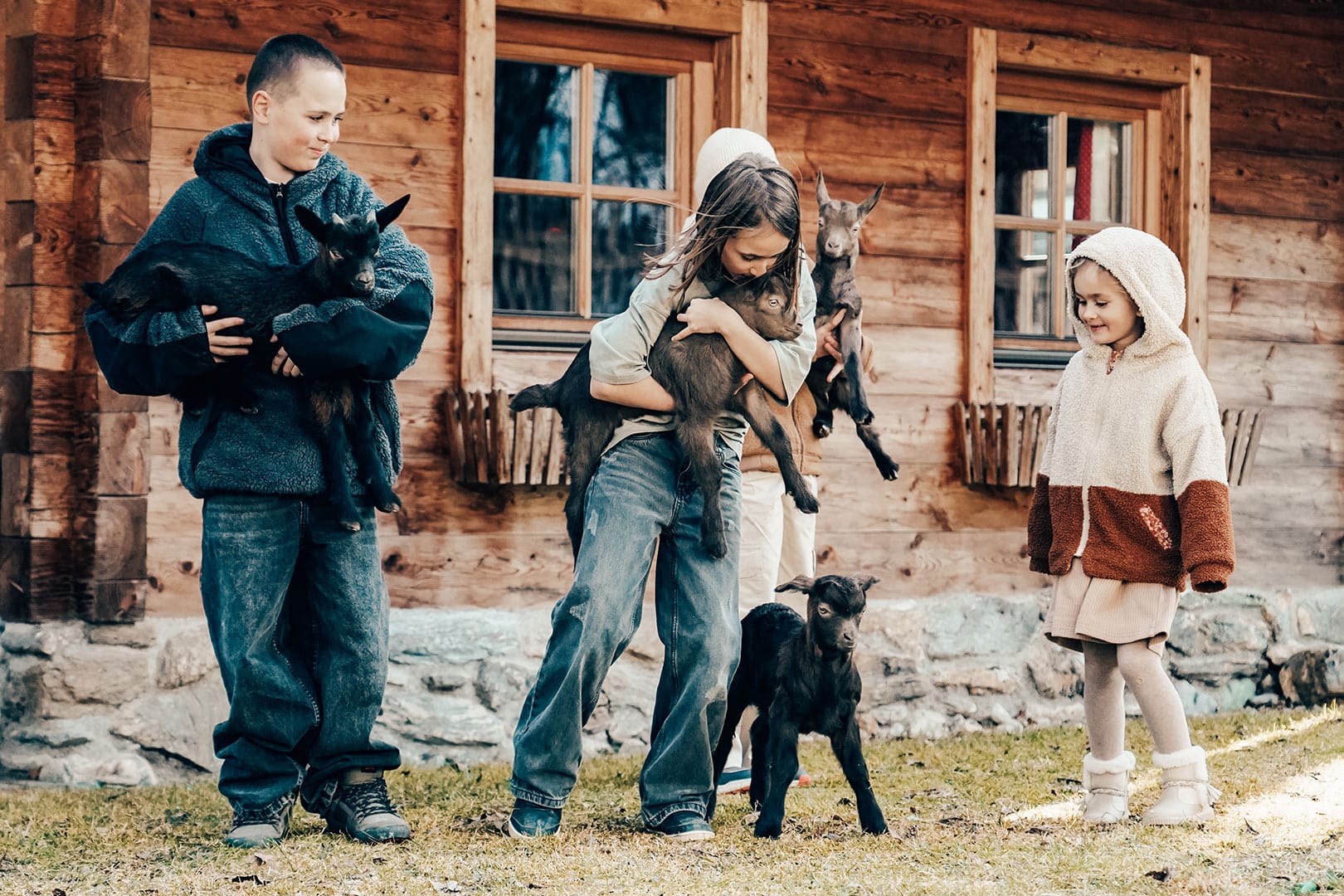 naturhof-eibl_bauernhof-6 Kinder kuscheln liebevoll mit Valdostana Ziegen auf dem Naturhof in Großarl