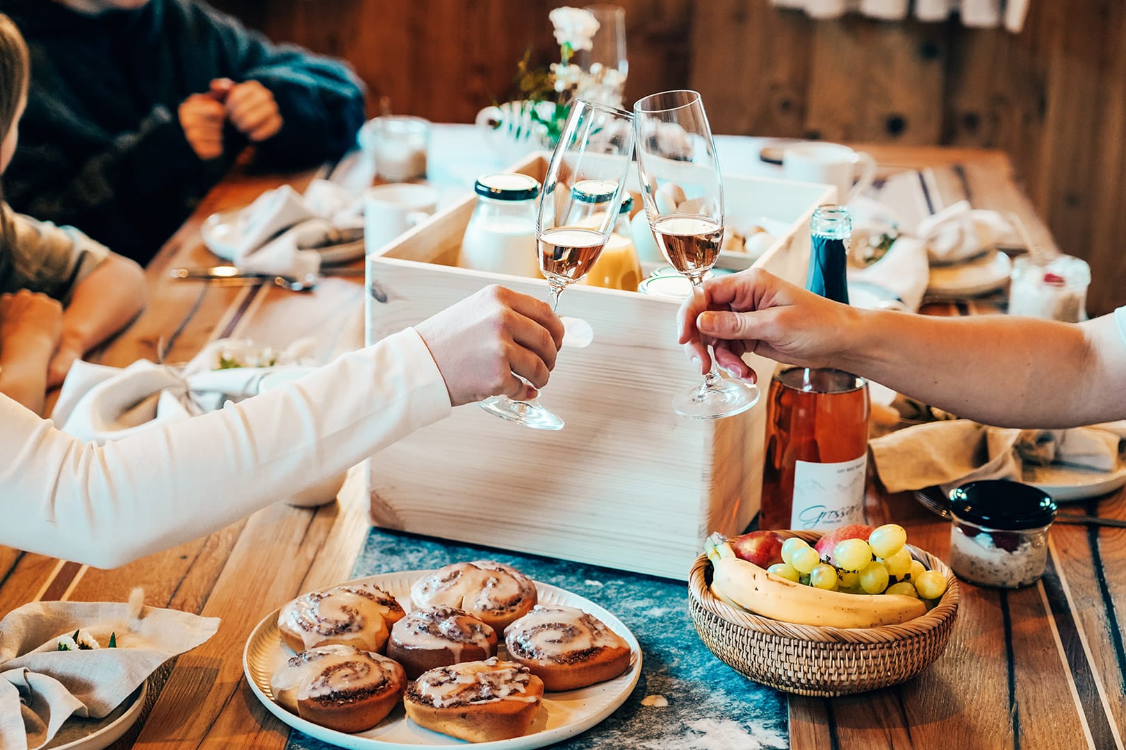 Frühstücksbox mit frischen, lokalen Zutaten und Anstoßen mit Großarler Wein am Tisch