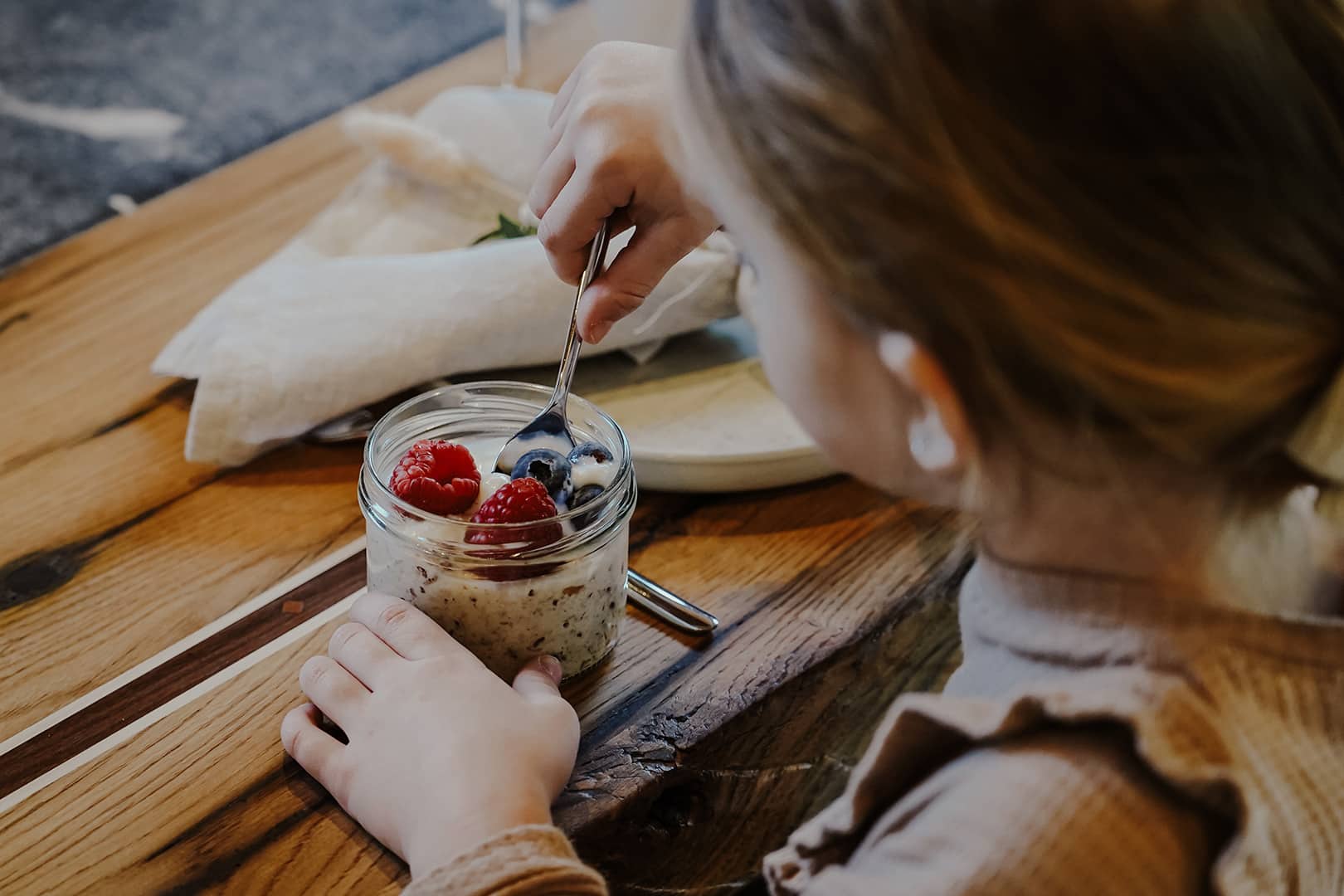 naturhof-eibl_fruehstuecksbox-5 Kind isst lokales Joghurt aus der Frühstücksbox am Naturhof Eibl